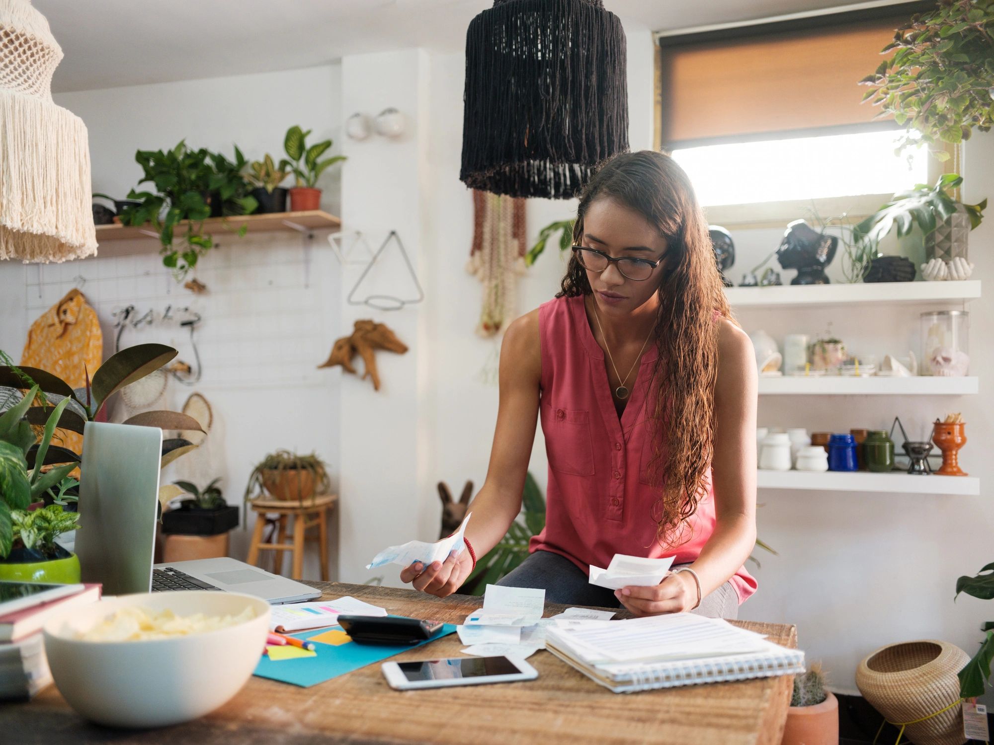 Person calculating costs with receipts and calculator