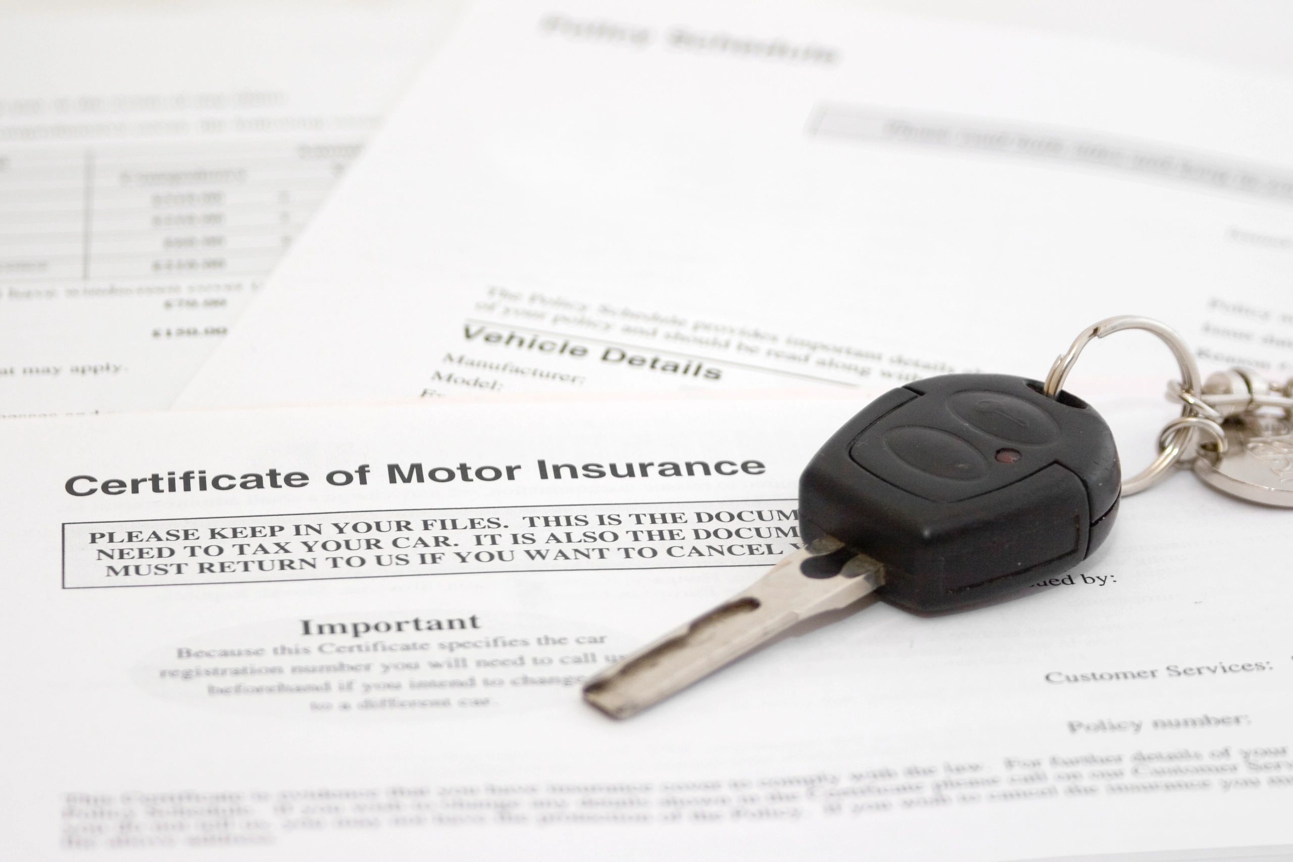 Car key and contract paperwork on a desk