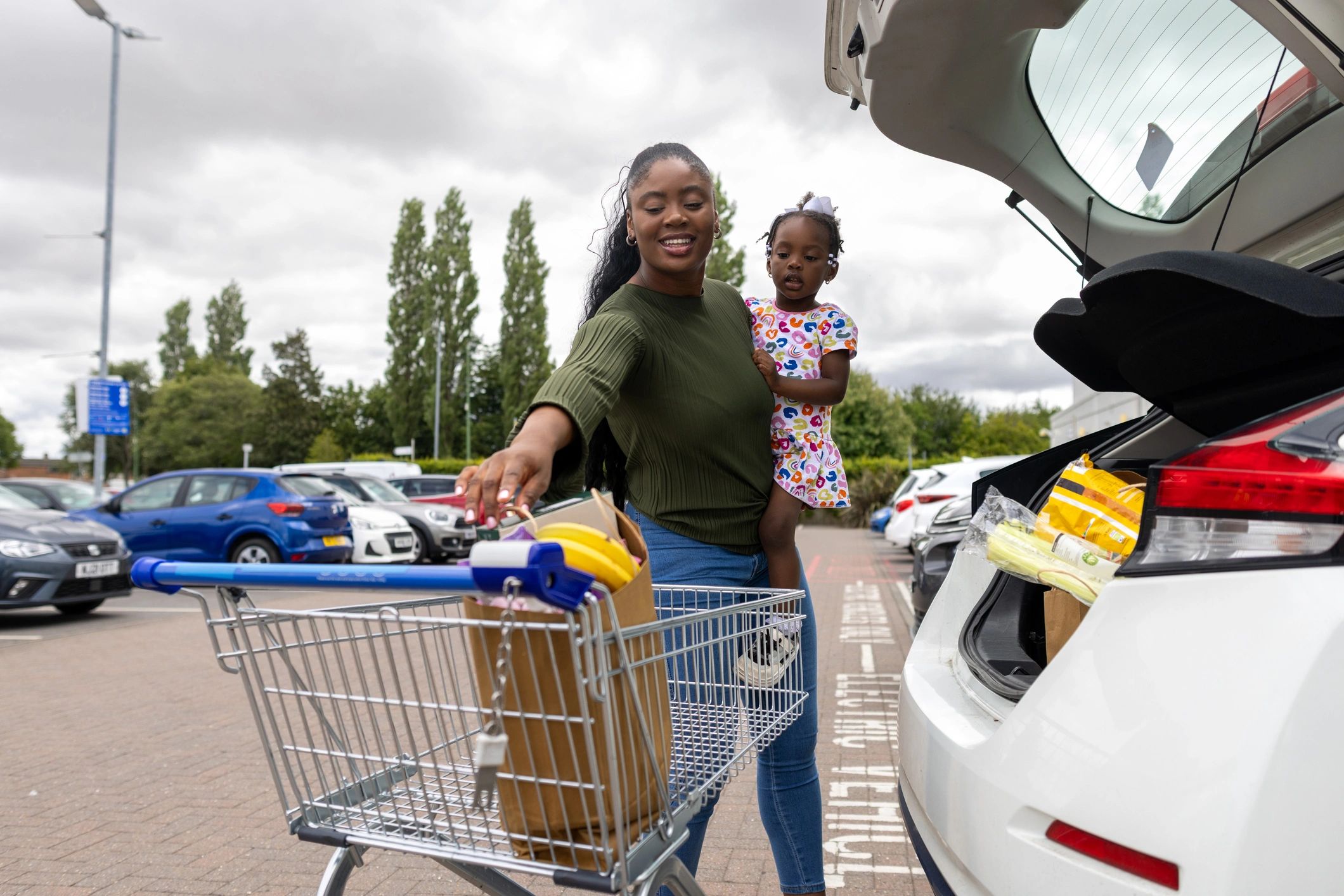 Family planning a vehicle purchase in a parking lot