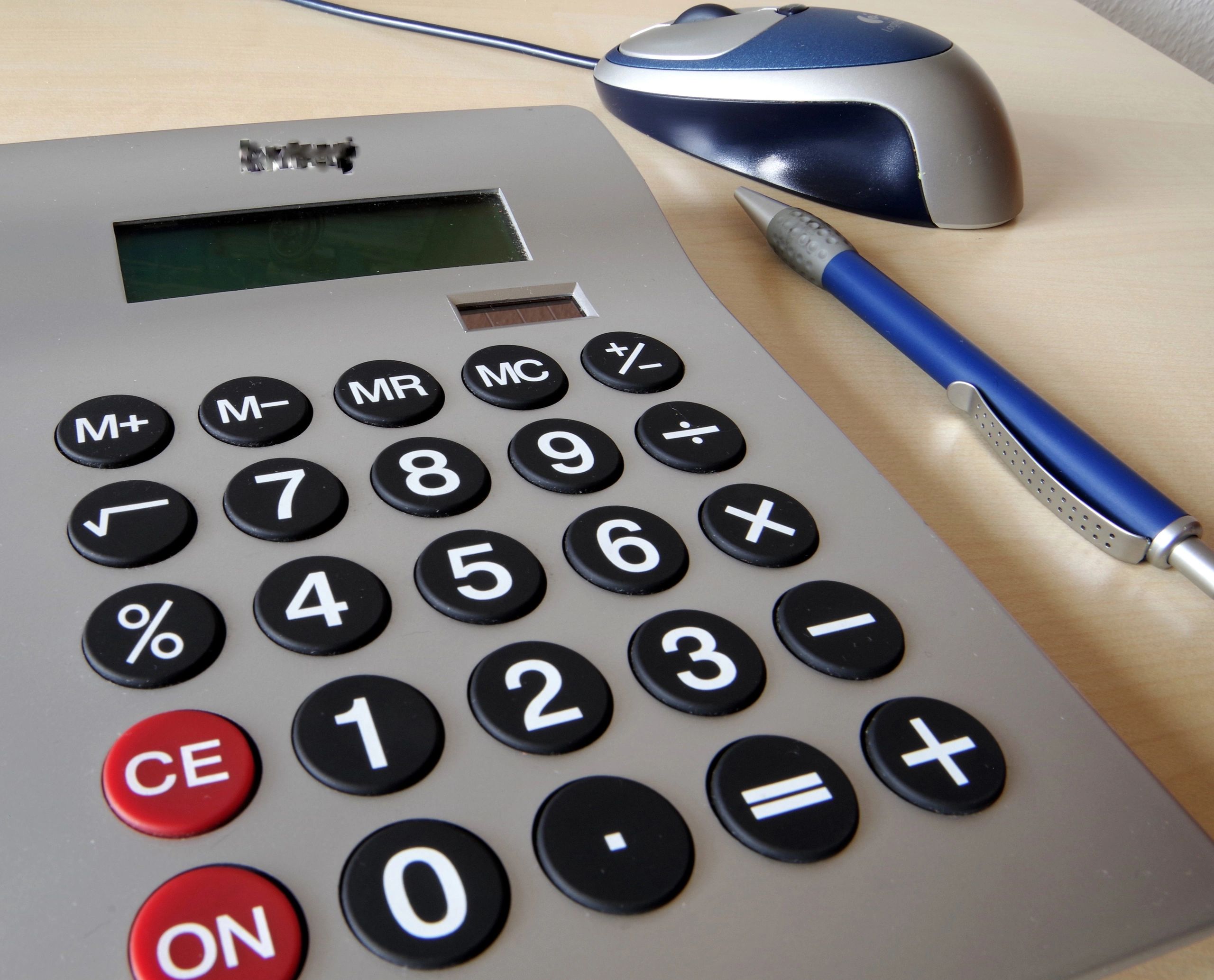 Calculator and pen beside financial planning materials